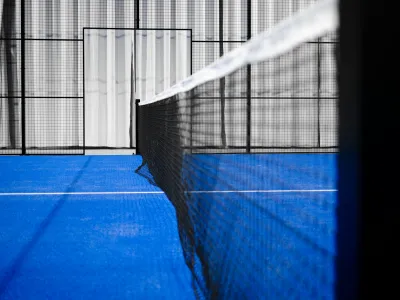Red y piso azul de una cancha de pádel techada