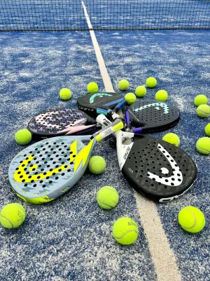 Raquetas y pelotas de pádel sobre la cancha