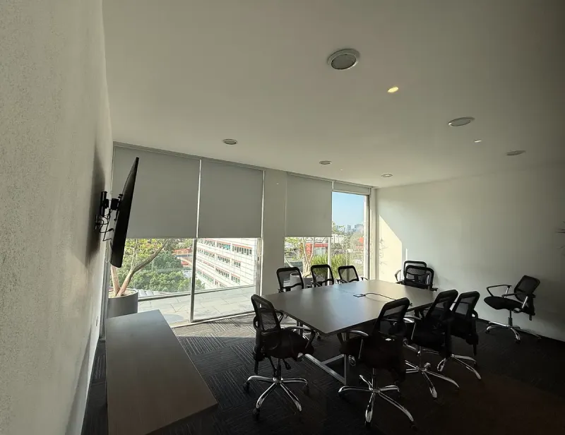 Sala de juntas con pantalla y vista a la ciudad